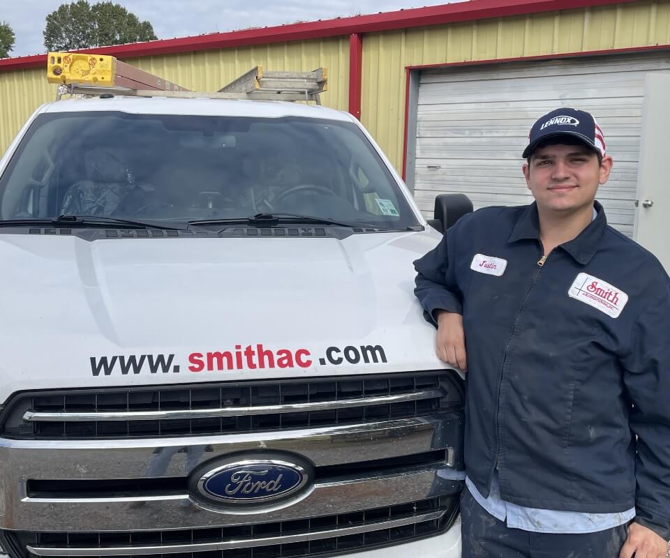 Technician Smiling Leaning On Truck
